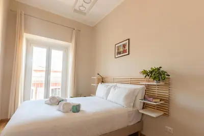 a bedroom with a large white bed with a window at Porta Pia apartment ZENO 53 in Rome