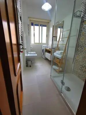 a bathroom with a white toilet and a bottle of hand soap at La Regina Tiberina in Rome