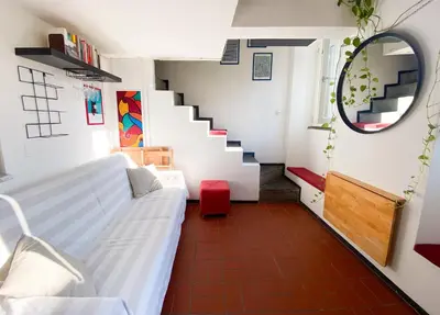 a living room with a white couch and a staircase at The Artful Flat in Rome