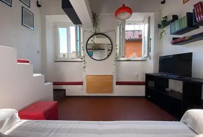 a room with a bed and a mirror and a television at The Artful Flat in Rome