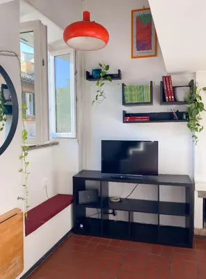 a living room with a tv and a shelf at The Artful Flat in Rome