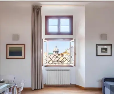 a living room with a window with a view of a building at HC - Palazzo Altieri Exclusive Penthouses in Rome