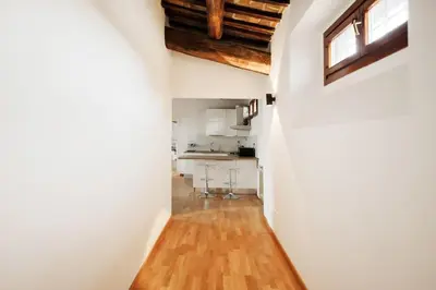 a kitchen with white walls and a wooden floor at HC - Palazzo Altieri Exclusive Penthouses in Rome