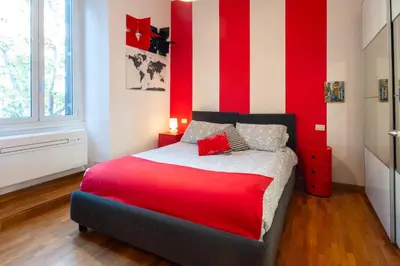 a bedroom with a red and white striped wall at Maison Doria Vaticano in Rome