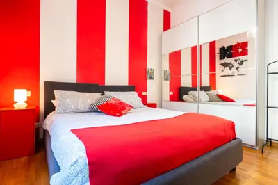 a red and white bedroom with a red and white striped wall at Maison Doria Vaticano in Rome