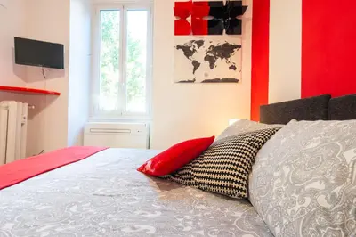 a bedroom with a bed with a red wall at Maison Doria Vaticano in Rome