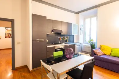 a living room with a table and a kitchen at Maison Doria Vaticano in Rome