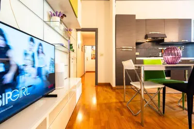 a living room with a tv and a table with chairs at Maison Doria Vaticano in Rome
