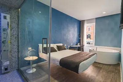 a bedroom with a bed and a bath tub next to a bathroom at Ripetta Relais in Rome