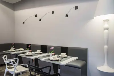 a dining room with tables and chairs and lights at Ripetta Relais in Rome