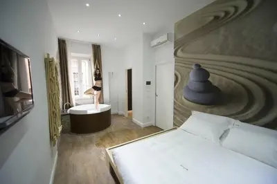 a bedroom with a bed and a woman standing on a tub at Ripetta Relais in Rome