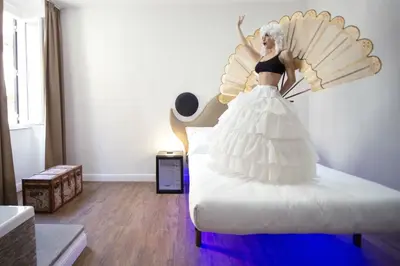a woman in a white dress on a bed at Ripetta Relais in Rome