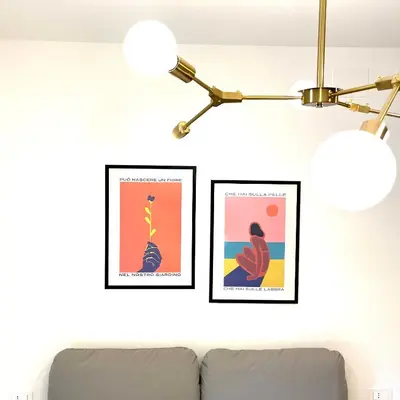 two framed posters on a wall next to a couch at Simposio - Luxury Apartment Rome in Rome