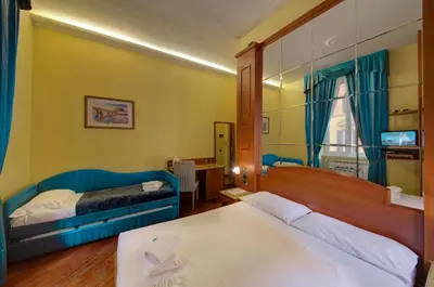 a hotel room with two beds and a mirror at 69 Manin Termini in Rome