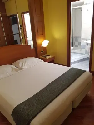a bedroom with a large bed with a door to a balcony at 69 Manin Termini in Rome