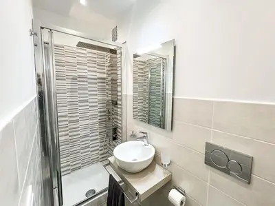 a white bathroom with a sink and a mirror at Stelletta Apartment in Rome