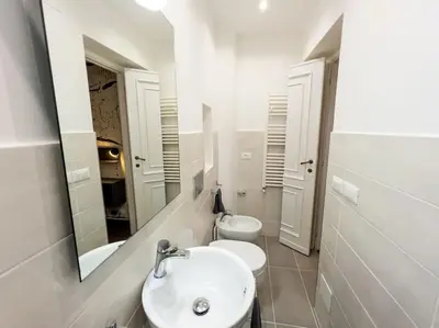 a bathroom with a sink and a toilet and a mirror at Stelletta Apartment in Rome