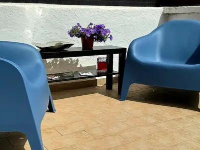 a table with two blue chairs and a table with purple flowers at Blue Sky in Rome