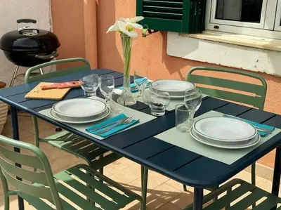 a blue table with plates and glasses and a flower on it at Blue Sky in Rome