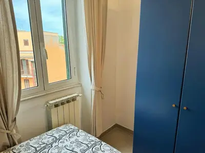 a bedroom with a blue door and a window at Blue Sky in Rome
