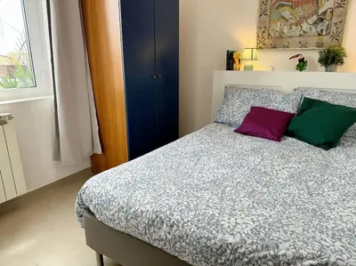 a bedroom with a bed with purple and green pillows at Blue Sky in Rome
