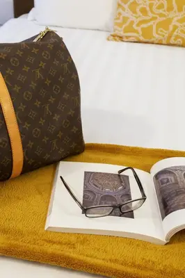 a book and glasses on top of a bed at Vatican 44 in Rome
