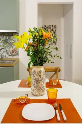 a table with a plate and a vase with flowers at Vatican 44 in Rome