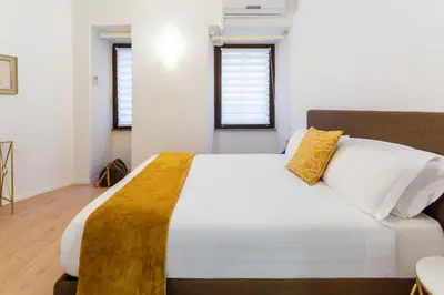 a bedroom with a large white bed with yellow pillows at Vatican 44 in Rome
