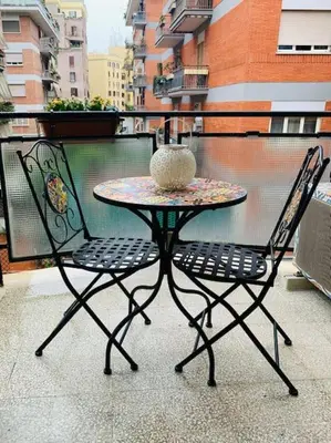 a patio table and two chairs with a vase on it at Portami in Villa -Gianicolo in Rome