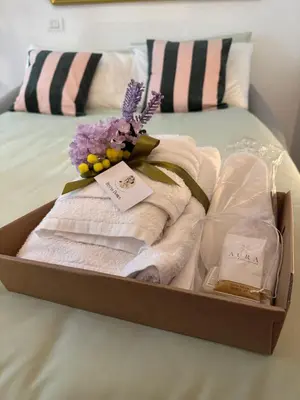 a box with towels and a bouquet of flowers on a bed at Hestya Domus in Rome