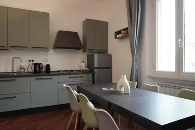 a kitchen with a table with chairs and a refrigerator at Holidays Palumbo in Rome