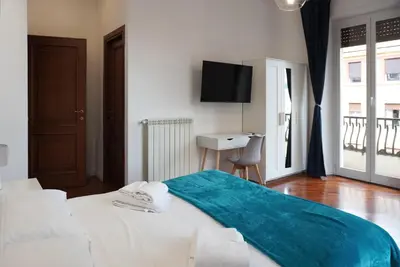a bedroom with a bed with a television on the wall at Holidays Palumbo in Rome