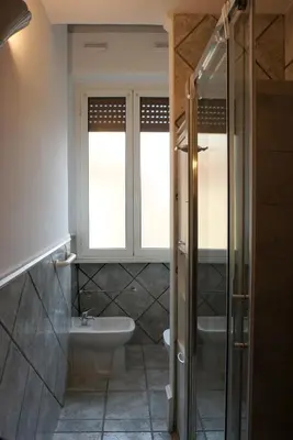 a bathroom with a sink and a toilet and a window at Holidays Palumbo in Rome