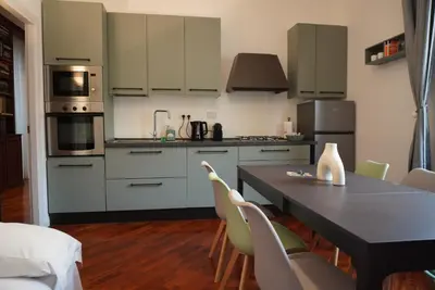 a kitchen with white cabinets and a table and chairs at Holidays Palumbo in Rome