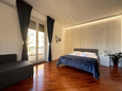 a bedroom with a bed and a couch and a window at Holidays Palumbo in Rome