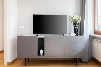 a white entertainment center with a flat screen tv on it at Dona's House in Rome
