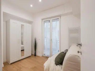 a white living room with a couch and a window at The Best Rent - Modern one-bedroom apartment in the Cipro area in Rome