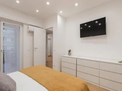 a bedroom with a bed and a tv on a wall at The Best Rent - Modern one-bedroom apartment in the Cipro area in Rome