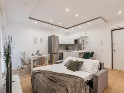 a bedroom with a large bed and a kitchen at The Best Rent - Modern one-bedroom apartment in the Cipro area in Rome