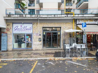 a store with tables and chairs in front of a building at The Best Rent - Modern one-bedroom apartment in the Cipro area in Rome