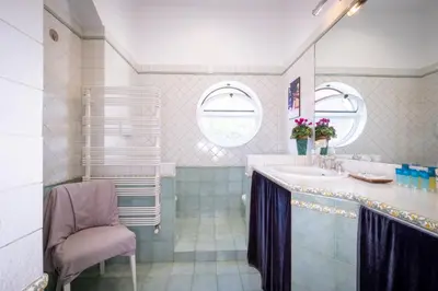 a bathroom with a sink and a chair at Vatican Museum apartment by Varental in Rome
