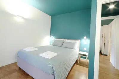 a bedroom with a bed and a blue wall at Casa di Paolo a Fontana di Trevi in Rome