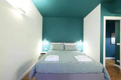a blue bedroom with a bed with two towels on it at Casa di Paolo a Fontana di Trevi in Rome