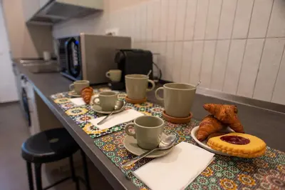 a counter with coffee cups and pastries on it at Colosseo Apartment 183 in Rome