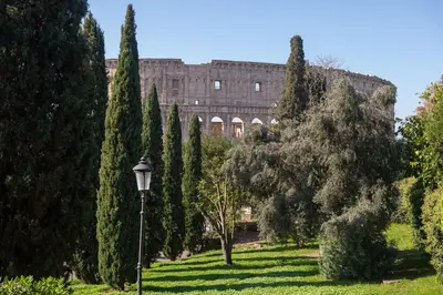 a park with trees and a building in the background at Colosseo Apartment 183 in Rome
