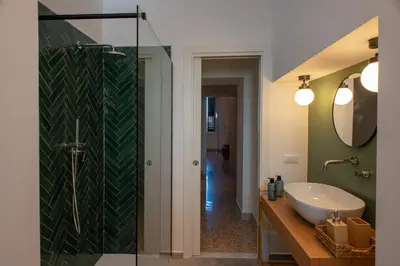 a bathroom with a sink and a glass shower at Colosseo Apartment 183 in Rome