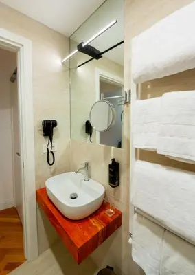 a bathroom with a sink and a mirror and towels at AGH - Capranica in Rome