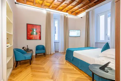 a hotel room with a bed and two chairs at AGH - Capranica in Rome