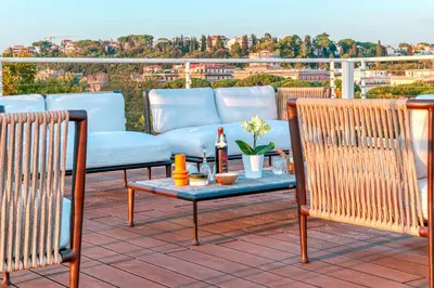 a patio with a couch and a table on a roof at Skylife Tiber Luxury Penthouse in Rome