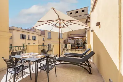 a table with chairs and an umbrella on a balcony at Skylife Minimalist Boutique Apartment in Rome